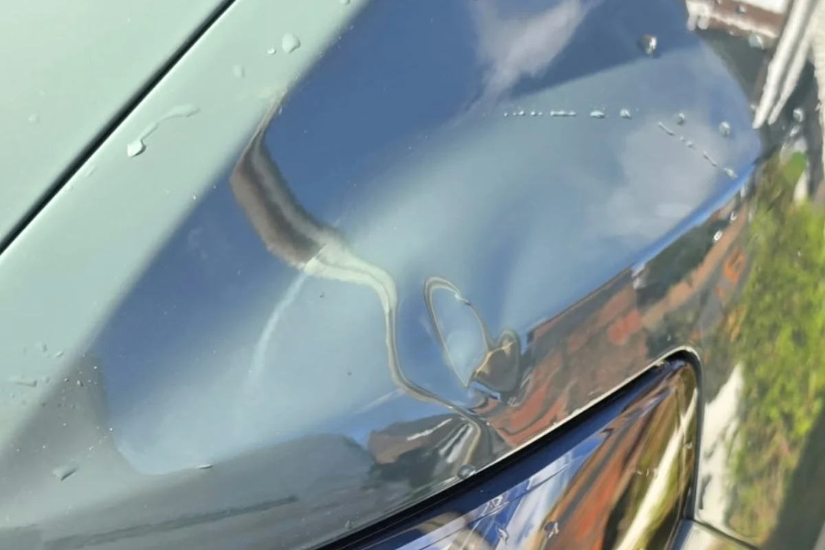Large dent in a car bonnet above the headlight